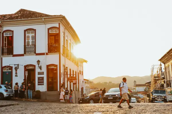 Cobblestone street in San Cristóbal at golden hour with cafés and people walking